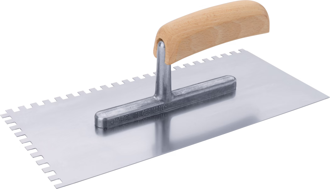Rechteckige Zahnkelle mit polierter Metallplatte und gebogenem Holzgriff; eine lange Kante hat gleichmäßig angeordnete quadratische Zähne und die Metallbefestigung ist mit „Made in Germany“ geprägt.