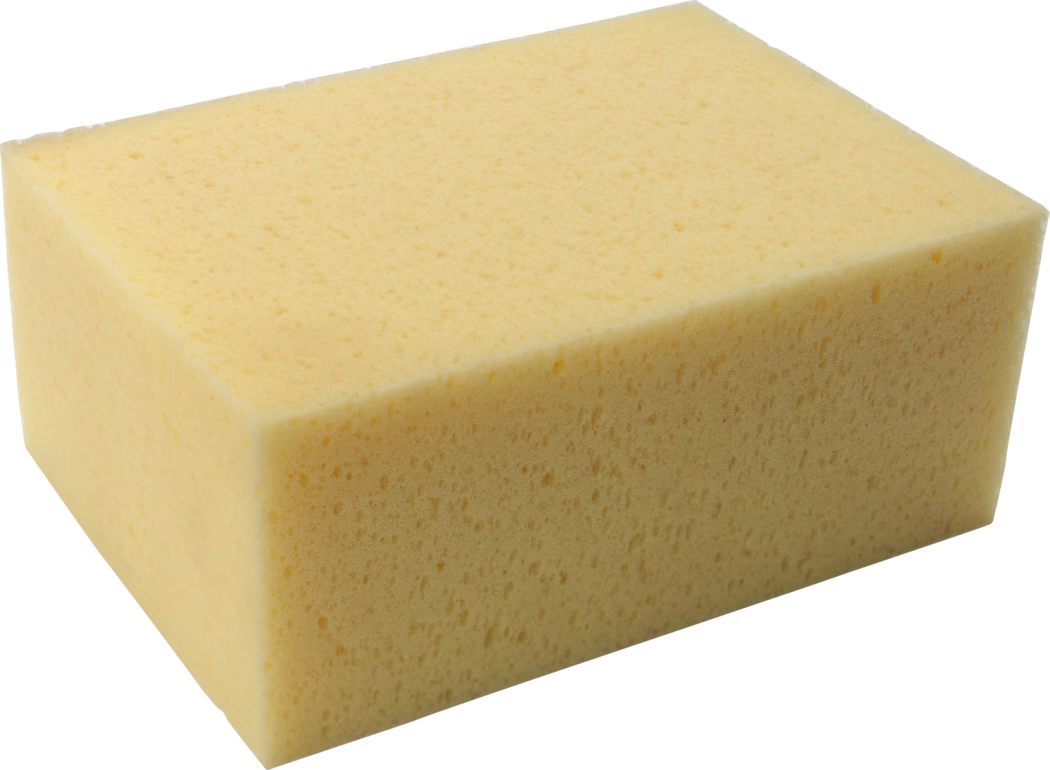 Pajarito_Dummy_Tile sponge_089391_2021-02 Ein rechteckiger gelber Reinigungsschwamm aus Schaumstoff mit feinen, gleichmäßigen Poren und geraden Kanten, aufgenommen vor weißem Hintergrund.