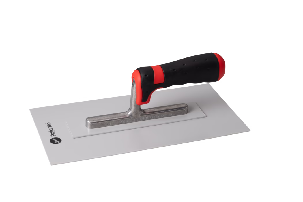 Eine rechteckige Glättkelle mit glatter weißer Metallplatte, einer zentralen gegossenen Metallaufhängung und einem ergonomischen schwarz-roten Gummigriff. Die flache Klinge ist groß und rechteckig, geeignet zum Glätten von Putz, Zement oder Mörtel an Wänden und Decken; der Griff ist leicht gebogen mit roten Akzenten und strukturiertem Halt. Das Werkzeug liegt auf weißem Hintergrund und wirkt sauber und neuwertig.