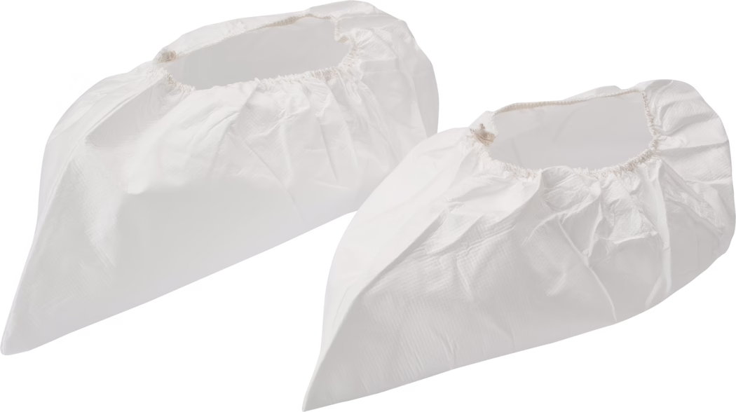 Pajarito_Dummy_Overshoes_034410_2021-02 Zwei weiße Einweg-Überschuhe aus leichtem, leicht strukturiertem Kunststoffmaterial liegen nebeneinander vor weißem Hintergrund. Jeder Überschuh verfügt über eine elastische Öffnung, eine spitz zulaufende Zehenform sowie sichtbare Falten und Nähte und deutet damit auf Einweg-Schutzschuhe für Reinräume, medizinische Bereiche oder Maler- und Wartungsarbeiten hin; ein Überschuh ist leicht hinter dem anderen positioniert, weiche Studio-Schatten betonen Volumen und Form.