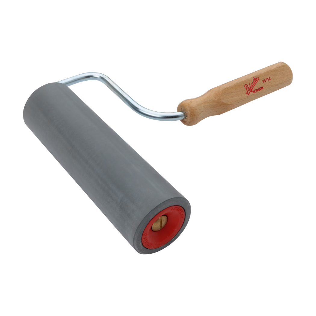 Handwerkzeug bestehend aus einer glatten, zylindrischen grauen Gummiwalze, montiert auf einem gebogenen Metallgestell mit hellem Holzgriff, der ein rotes Logo trägt. Die Walze besitzt eine rote Kunststoff-Endkappe mit sichtbarer Messingachse. Auf weißem Hintergrund in schräger Perspektive fotografiert; das Werkzeug wird üblicherweise zum Glätten von Tapeten, Laminaten oder zum Andrücken von Materialien verwendet.