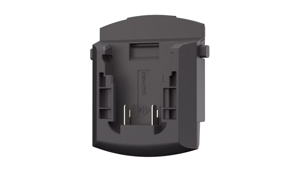 Pajarito_Dummy_Adapter DeWalt_181137_2024-08 Schwarzer mattierter Kunststoff-Akkupadapter bzw. -halter, von vorne gezeigt, mit einer rechteckigen Vertiefung und zwei freiliegenden Metallkontakten am unteren Bereich, Führungsnuten und seitlichen Verriegelungen, abgerundeter Unterkante und versenkten Montagemerkmalen; strukturierte Oberfläche und kleines eingeprägtes Recyclingsymbol sind sichtbar.