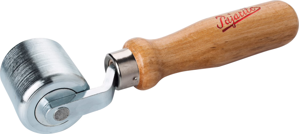 Nahaufnahme eines handlichen Nahtrollers mit einem kurzen, zylindrischen Metallroller und einem gedrechselten, hellbraunen Holzgriff. Der Roller besteht aus poliertem, leicht strukturiertem Stahl mit feinen Bearbeitungsspuren; er ist an einer kleinen verchromten Gabel befestigt, die drehbar in einer Metallhülse mit dem Griff verbunden ist. Der Holzgriff ist lackiert und ergonomisch geformt mit abgerundetem Ende; nahe dem Griffansatz befindet sich ein roter Schriftzug in Kursivschrift. Das Werkzeug ist isoliert vor weißem Hintergrund und gleichmäßig ausgeleuchtet fotografiert, sodass Oberflächenstrukturen, Spiegelungen und die Verbindung zwischen Roller und Griff gut sichtbar sind; es wird typischerweise zum Andrücken von Nähten und Glätten von Materialien wie Tapeten, Vinyl oder Leder verwendet.